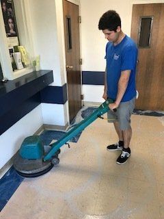 A man is using a machine to clean the floor in a room.