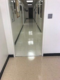 A long hallway with a door in the middle of it leading to a doorway.