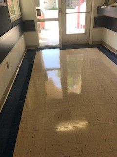 A hallway with a shiny tile floor and a door.