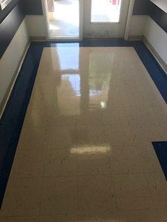 A hallway with a marble floor and a blue border.