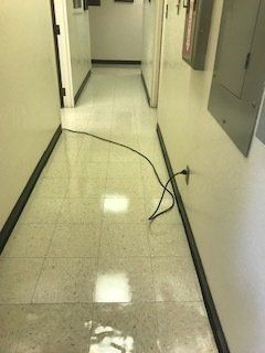 A long hallway with a power cord hanging from the wall.