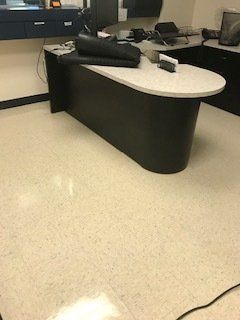 There is a desk in the middle of the room with a computer on it.