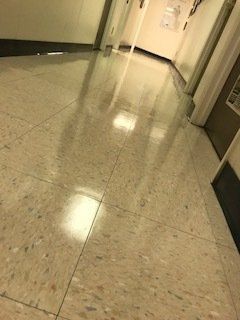 A hallway with a tiled floor and a door.
