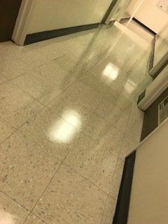 A hallway with a tiled floor and a door.