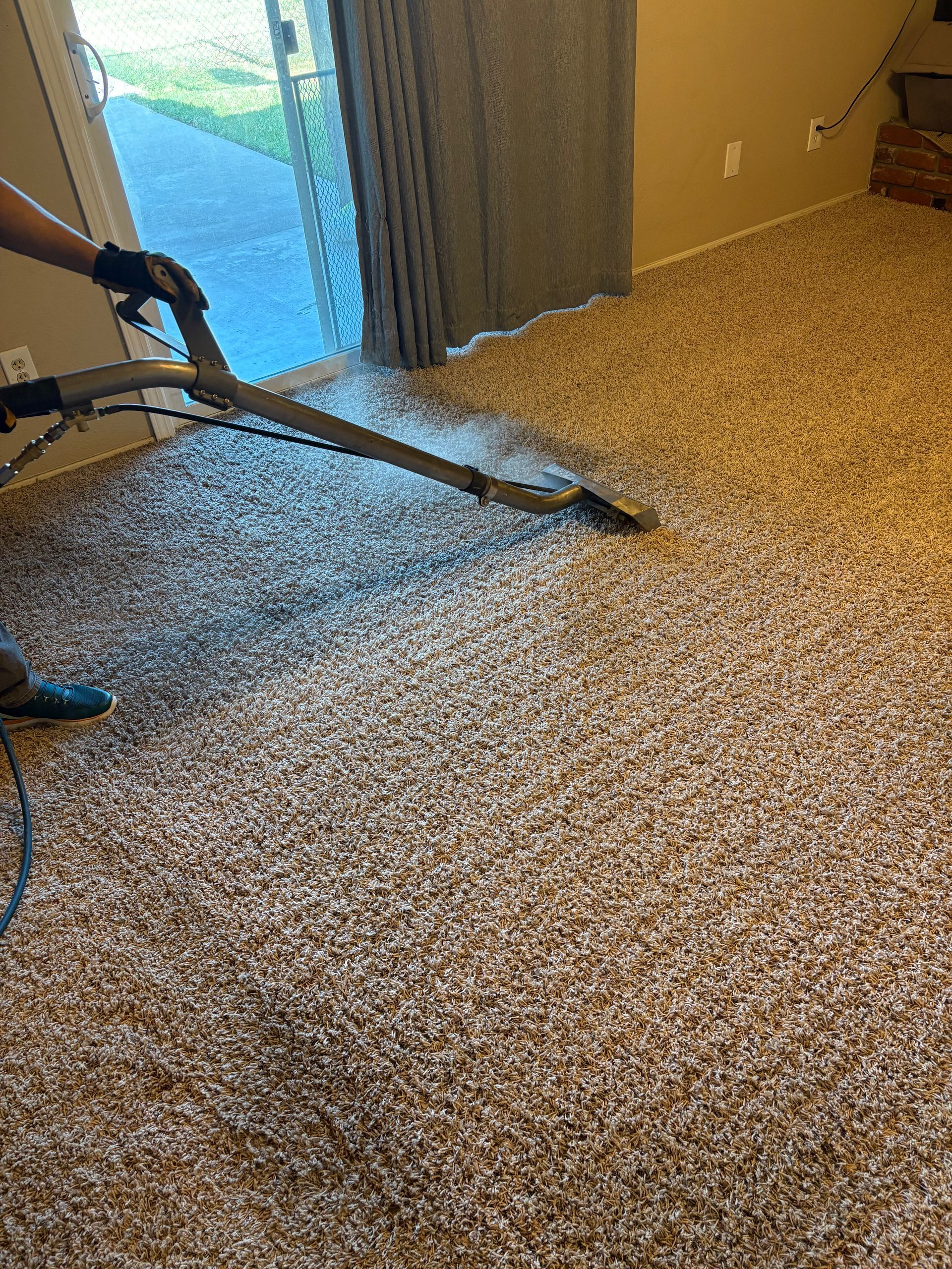 A person is using a vacuum cleaner to clean a carpet in a living room.