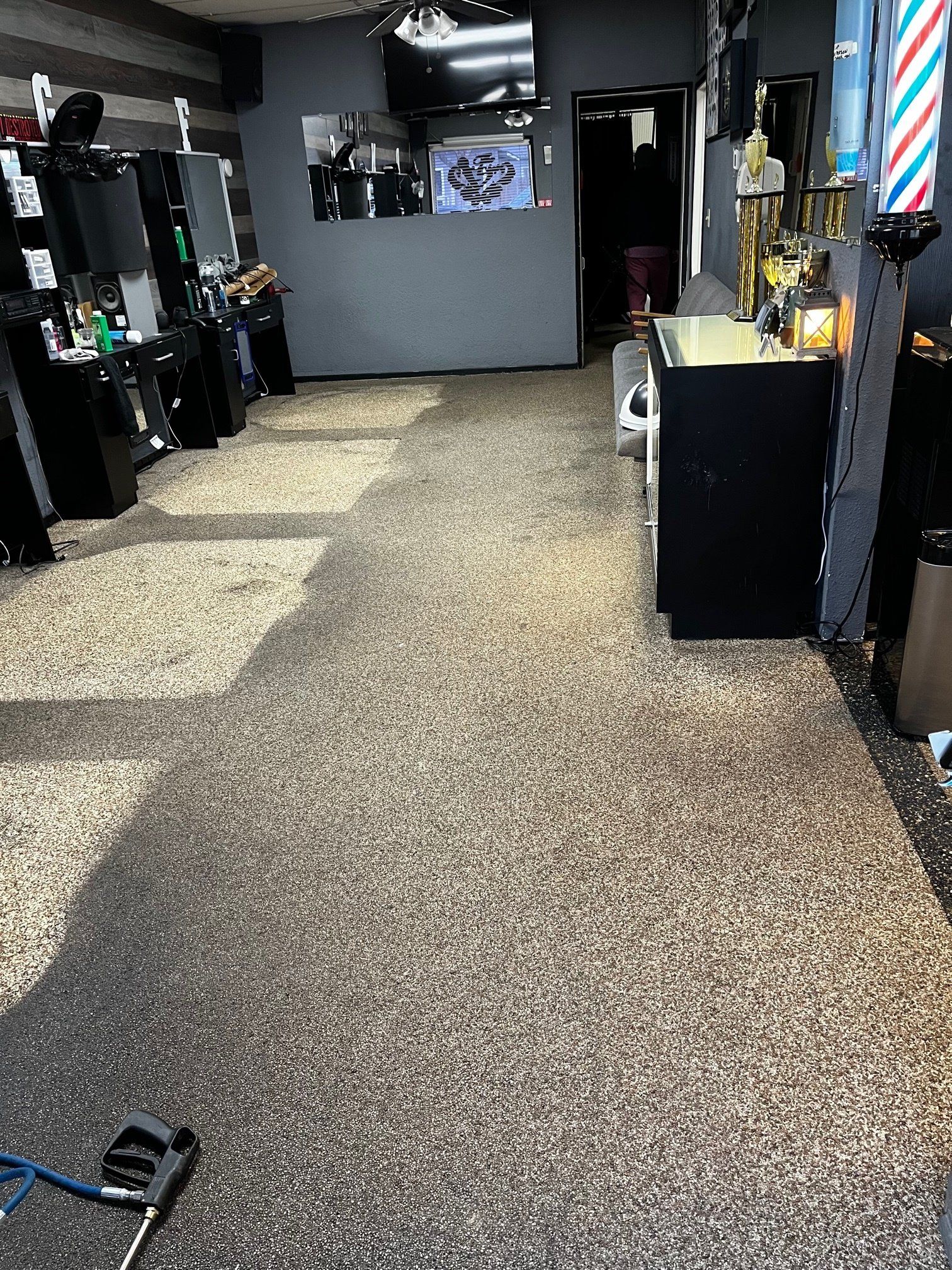 A barber shop with a striped barber pole in the middle of the room.