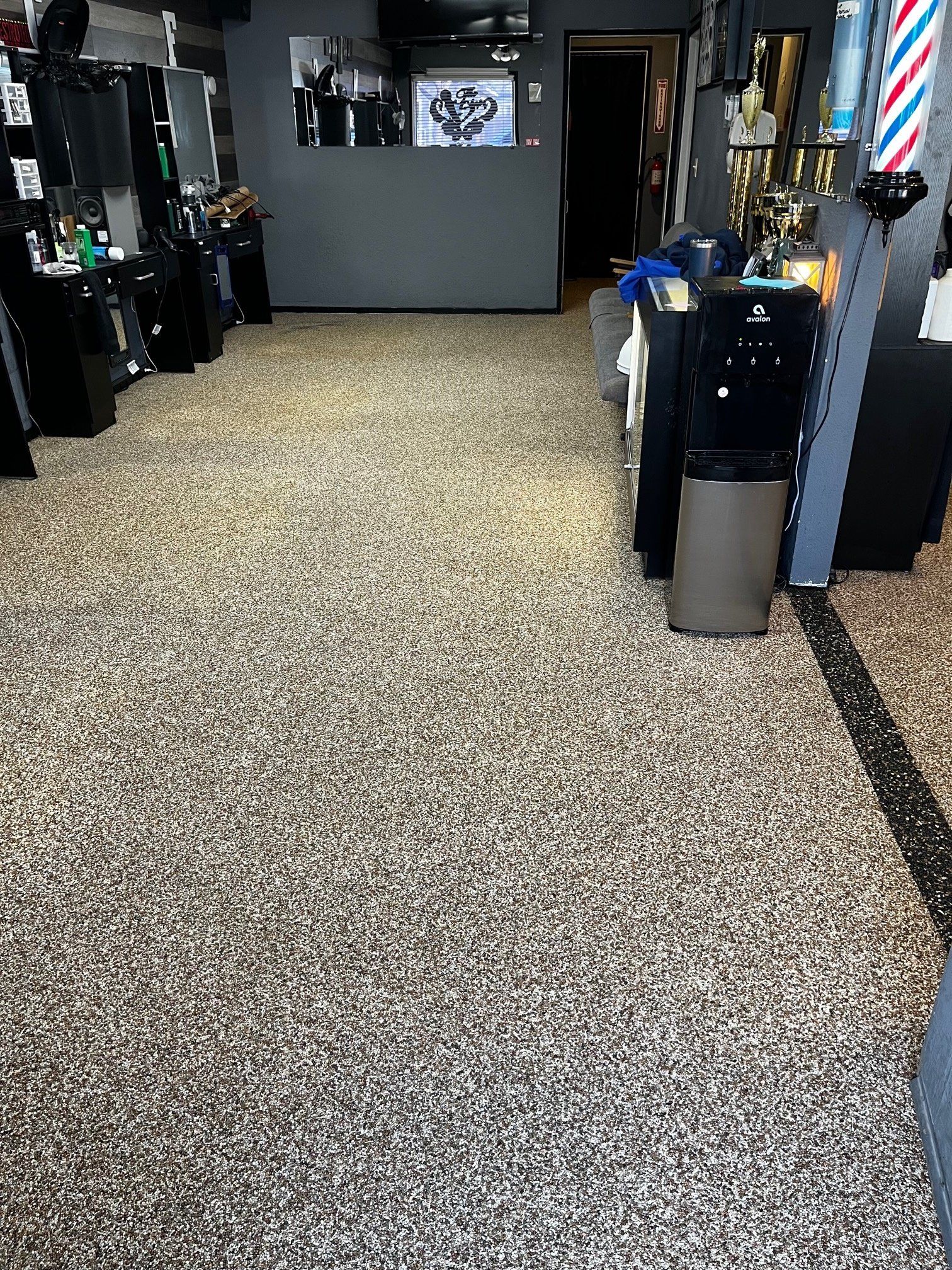 The floor of a barber shop is covered in gravel.