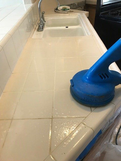 counter grout cleaning with blue equipment