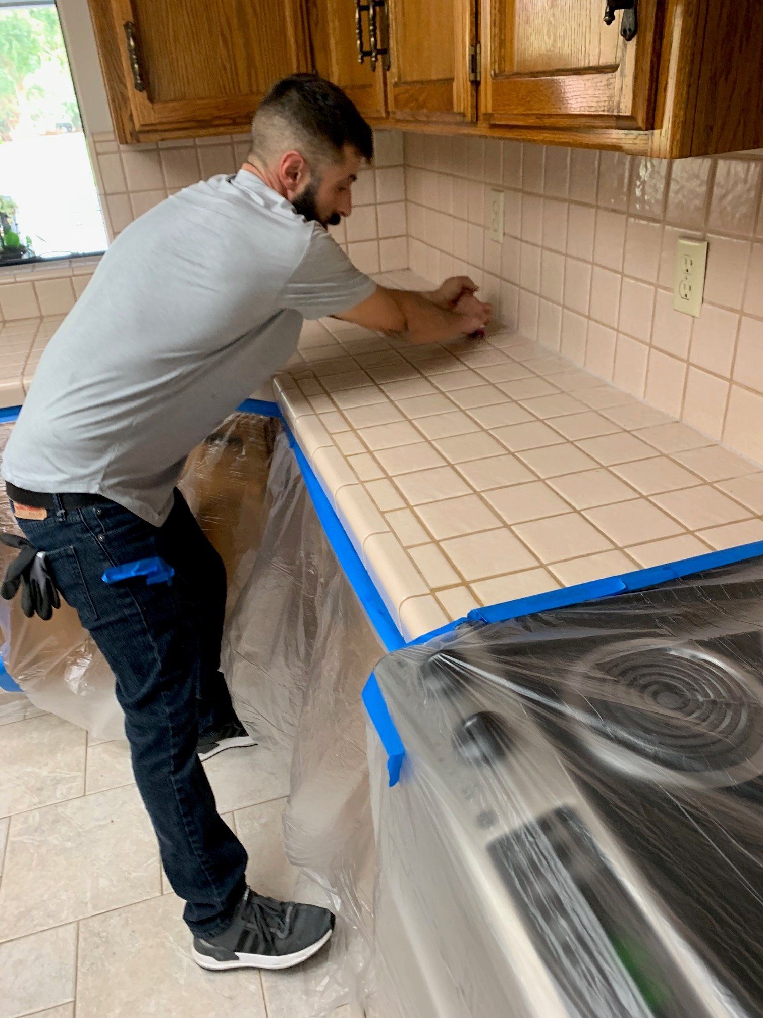 man cleaning kitchen counter tiles