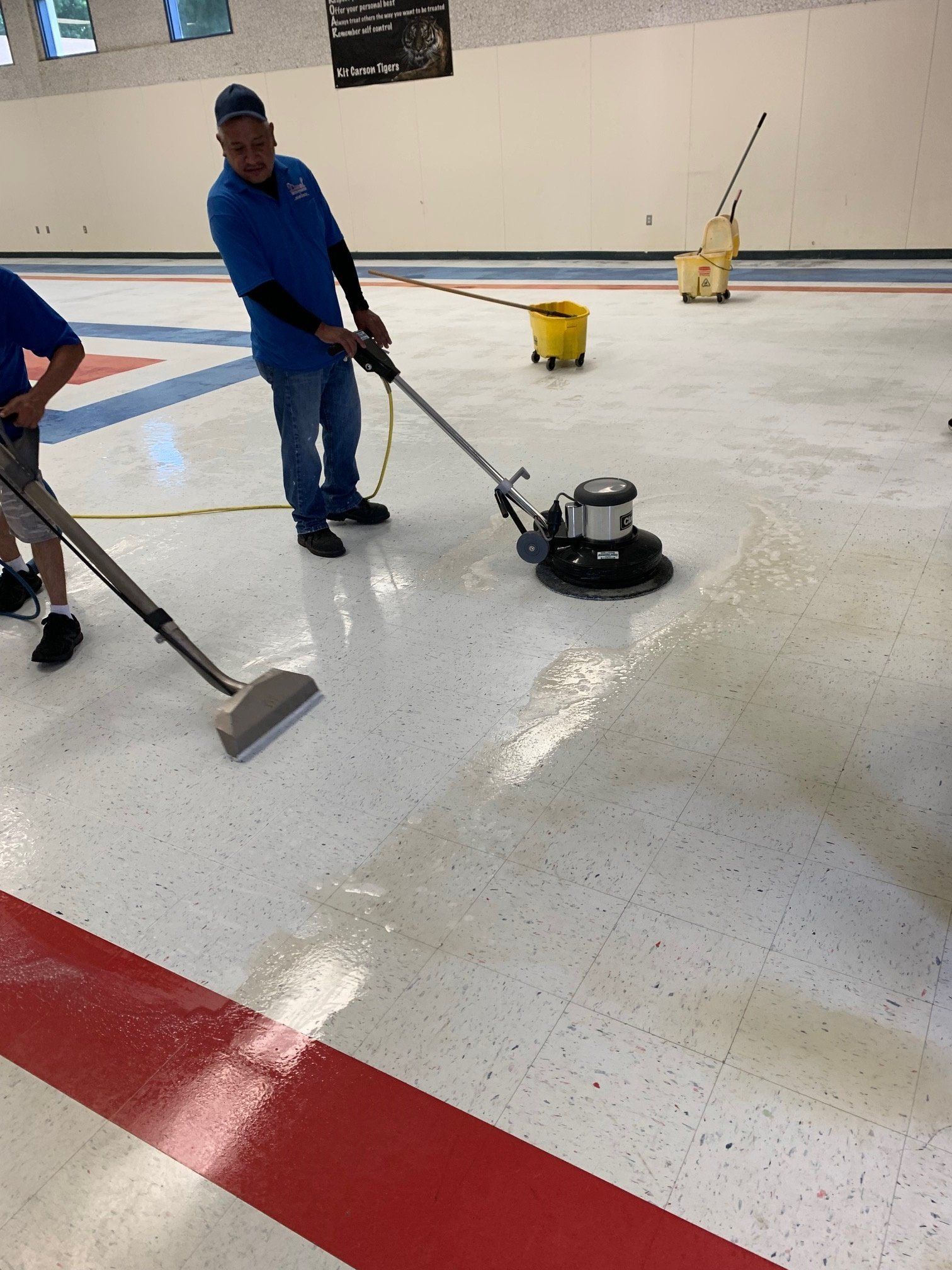 A man is cleaning the floor with a vacuum cleaner