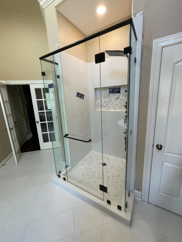 a bathroom with a frameless shower door and a sink