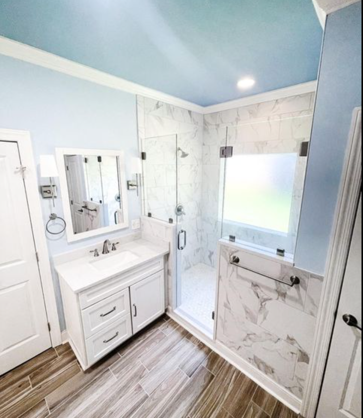 a bathroom with a sink, mirror, and walk in shower