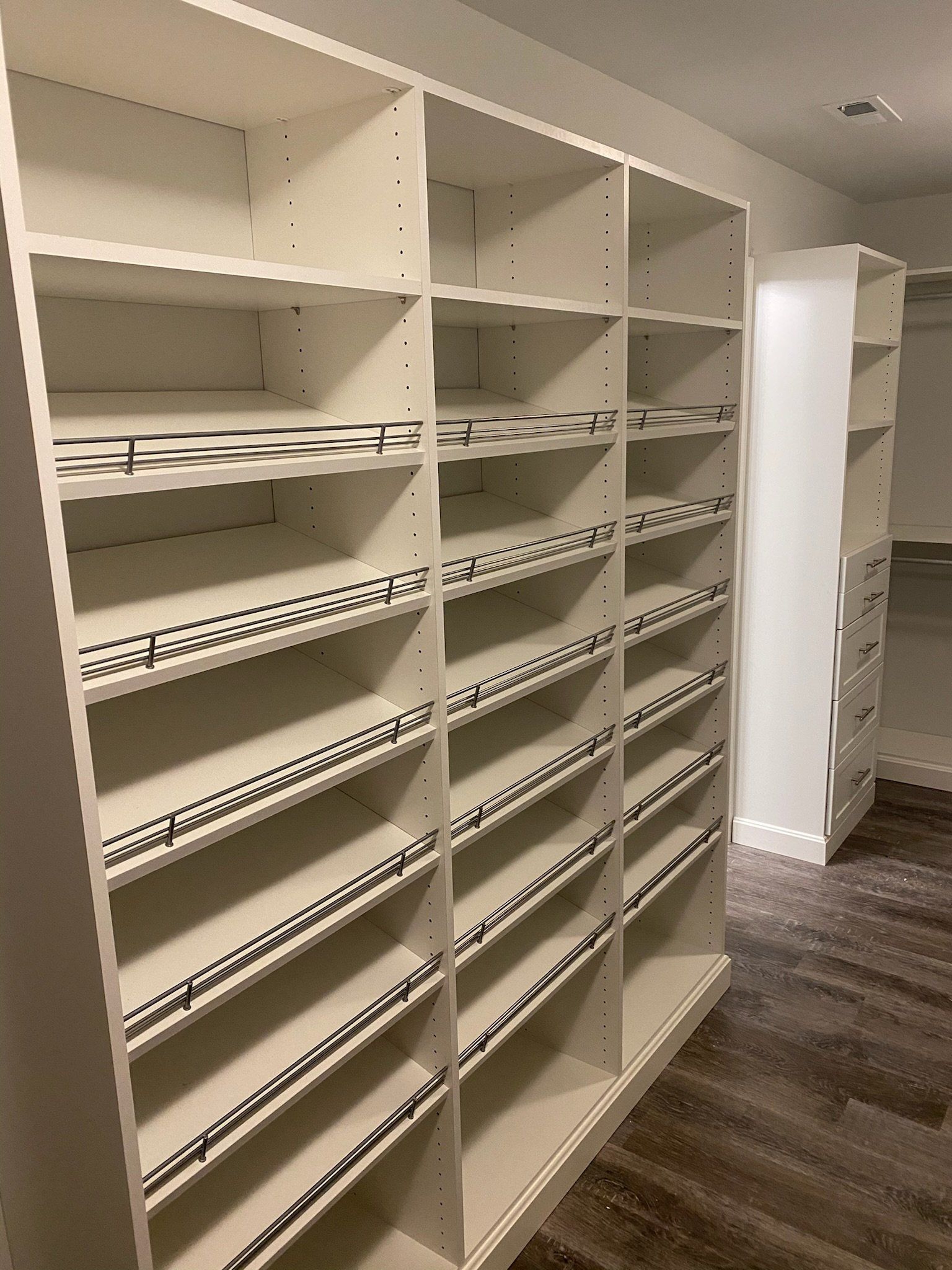 a room with a customized closet and a wooden floor