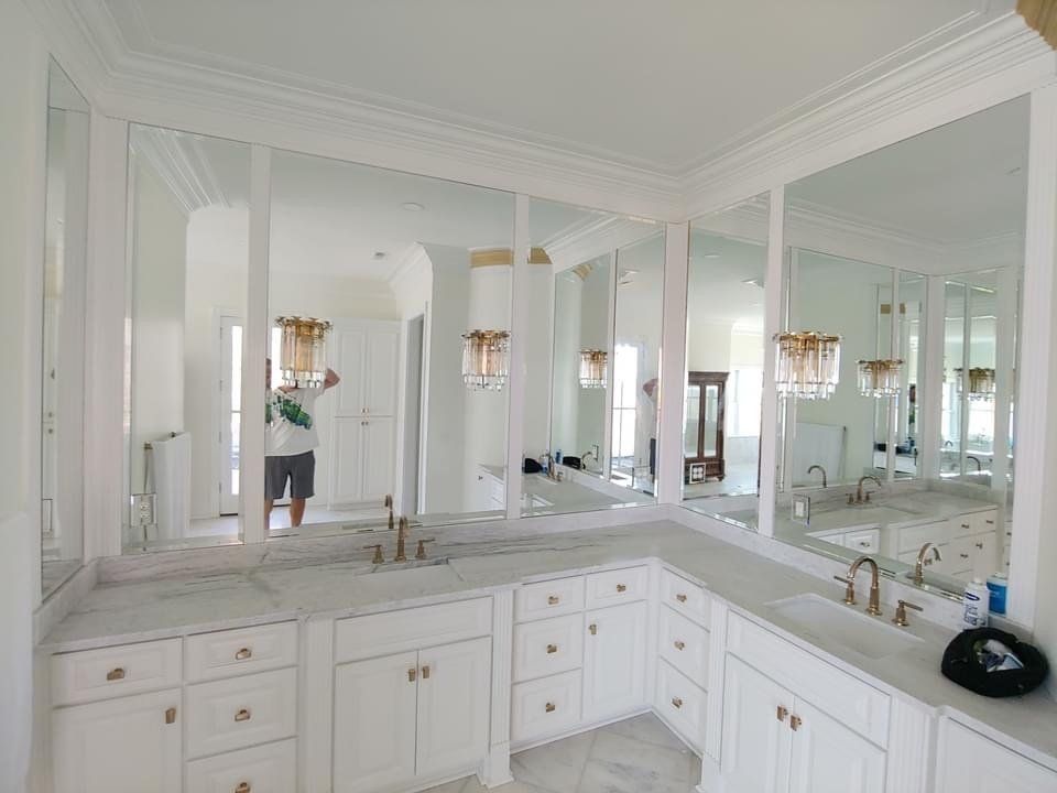 a bathroom with custom cabinets and 2 large mirrors