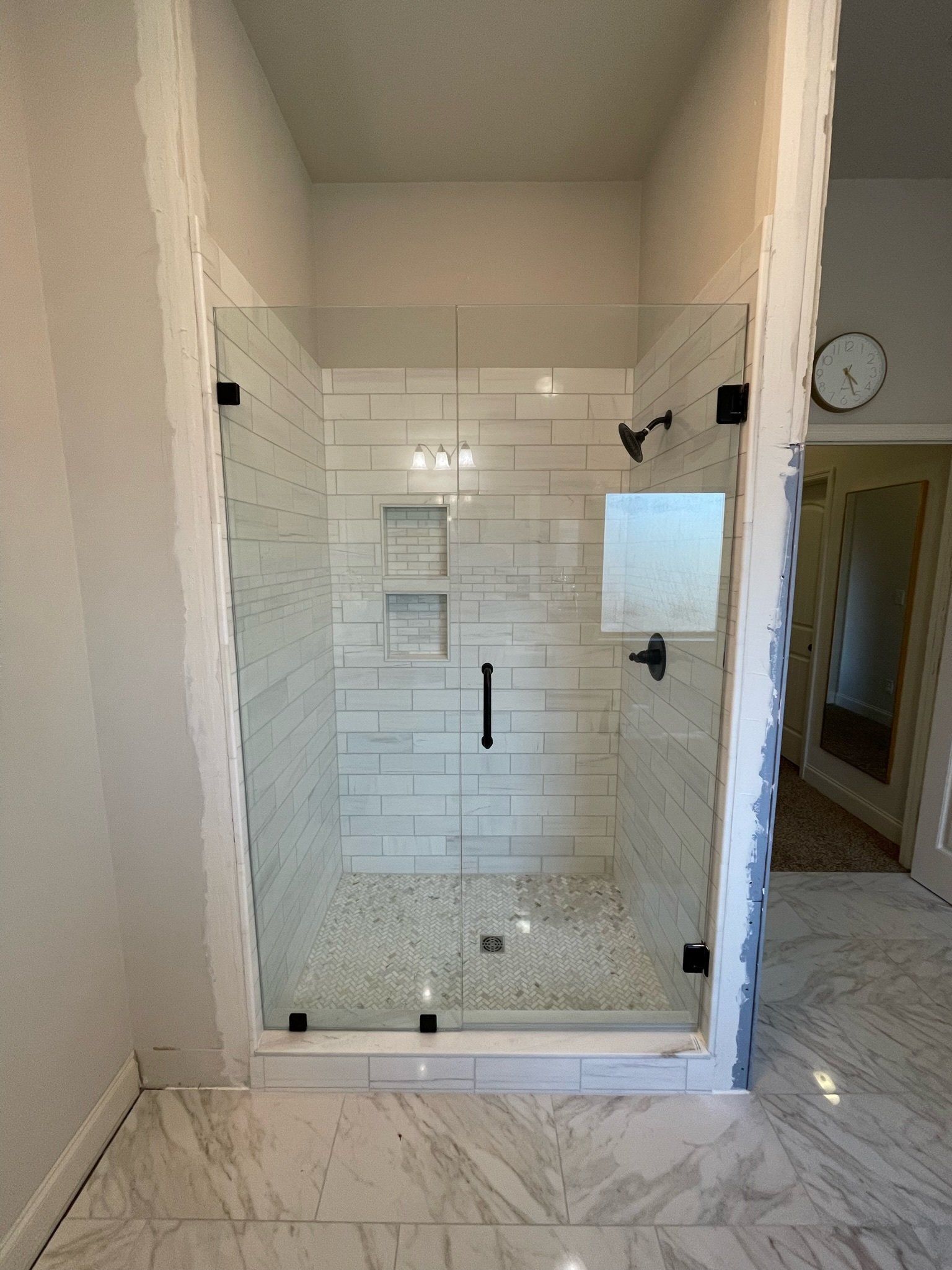 a bathroom with a walk in shower with a glass door