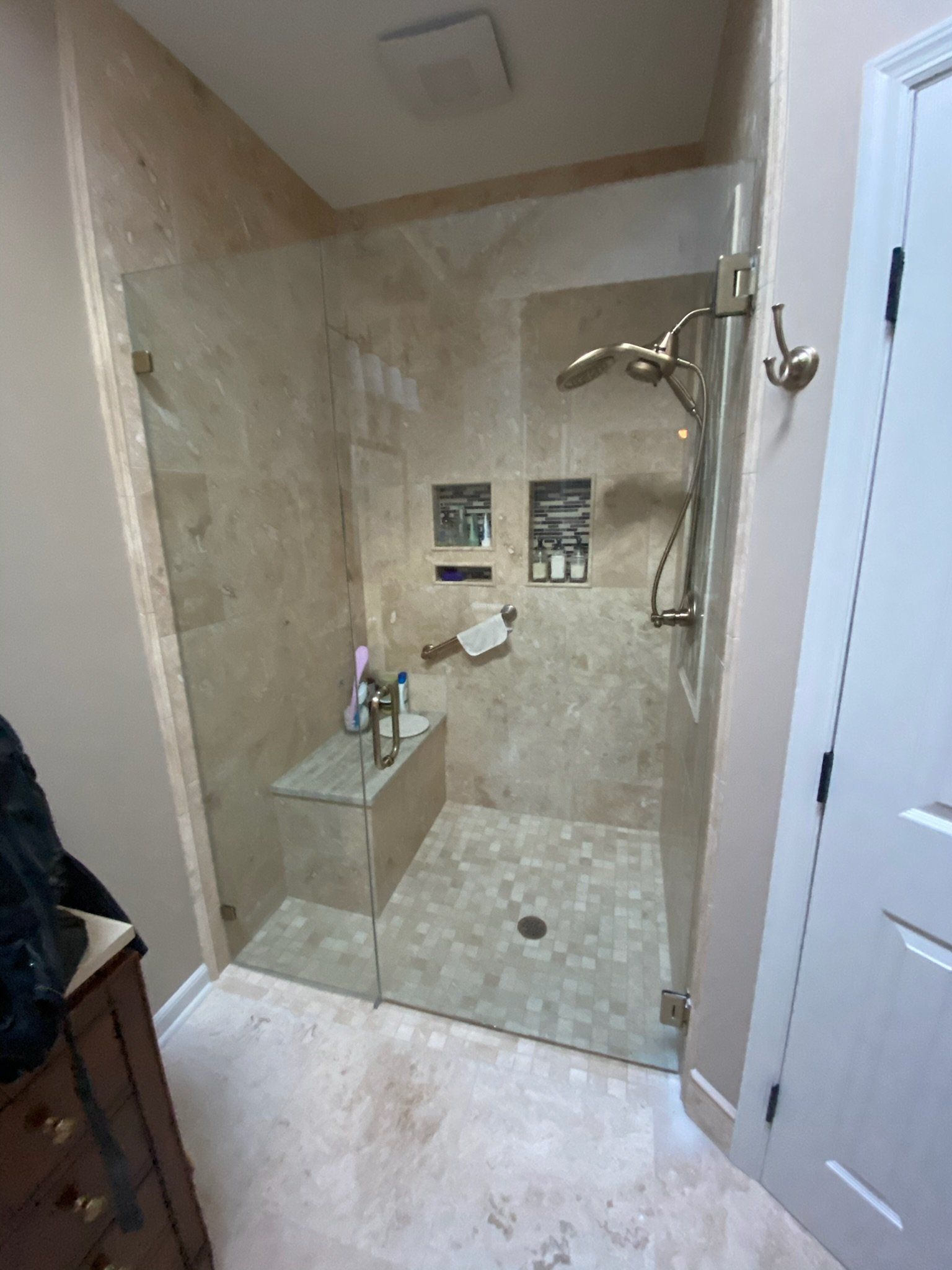 a bathroom with a walk in shower with a frameless glass door