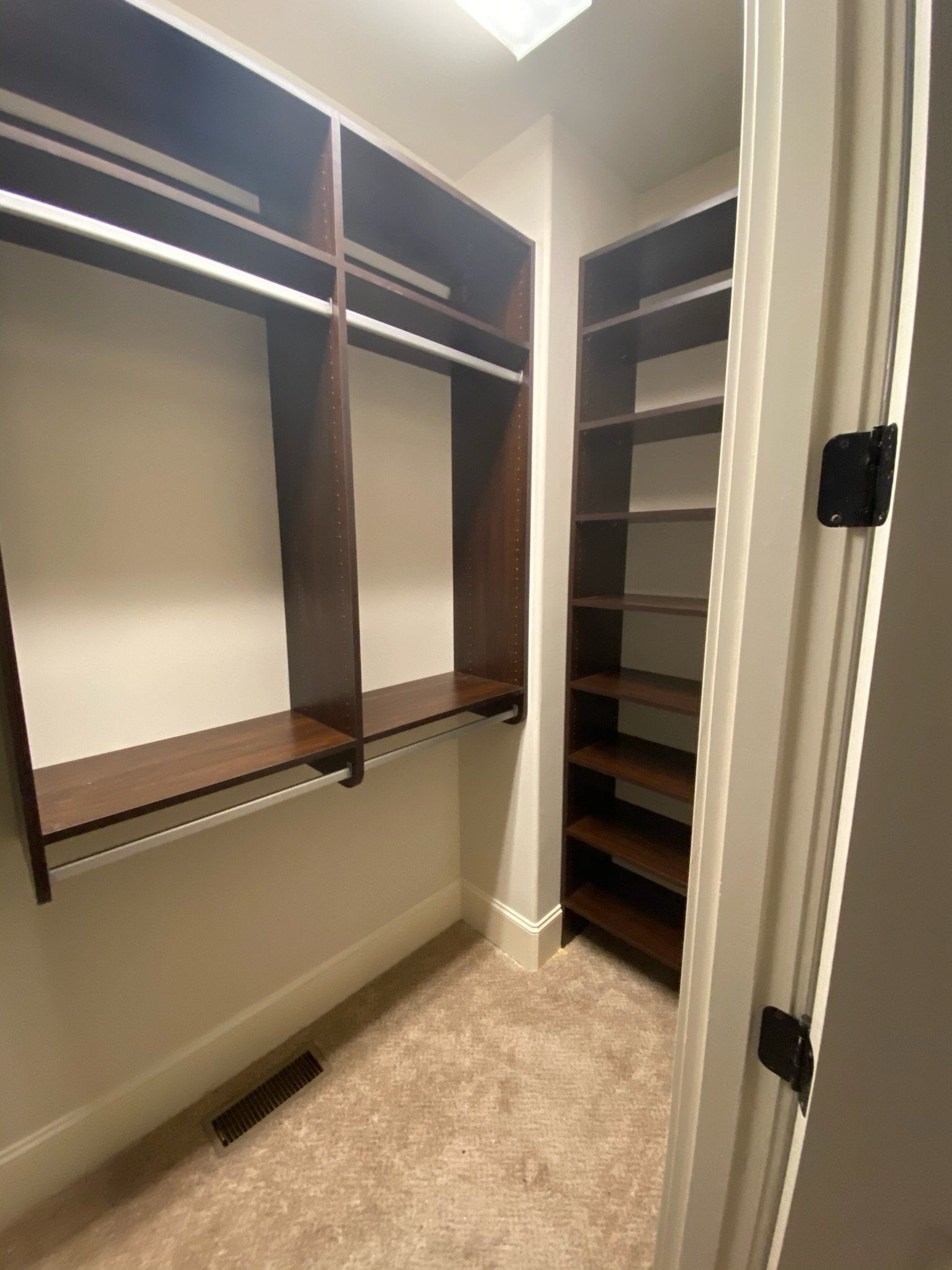 a walk in closet with lots of shelves