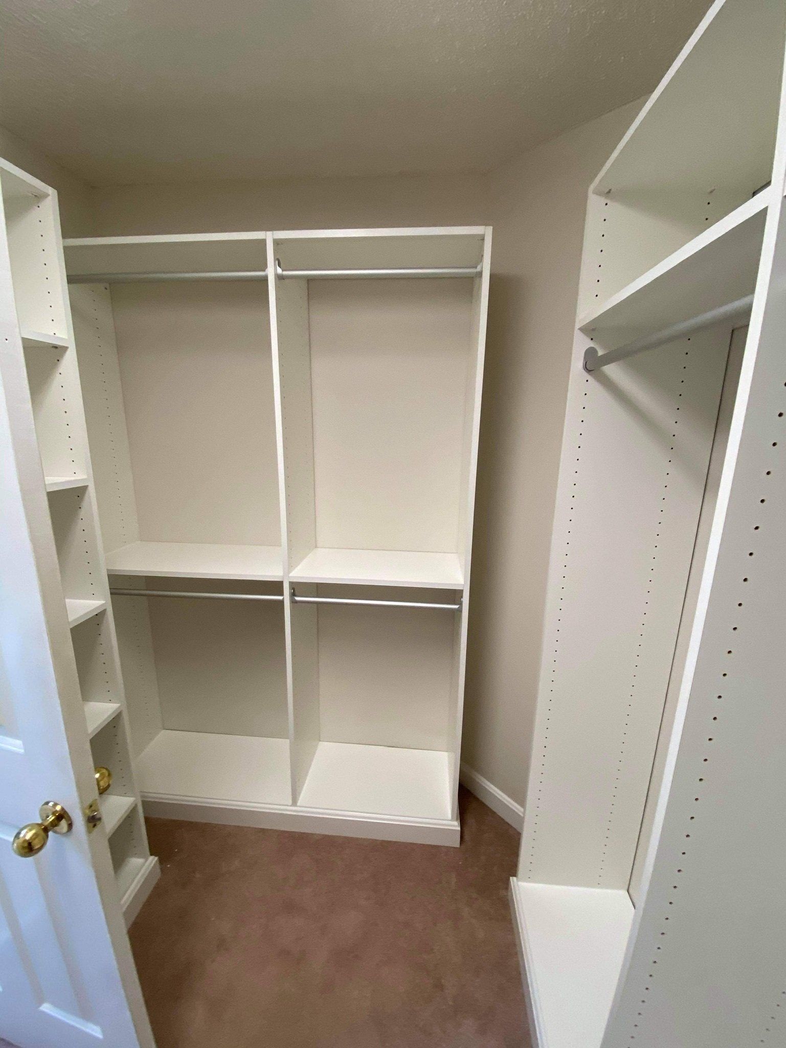 a walk in closet with lots of shelves and clothes racks