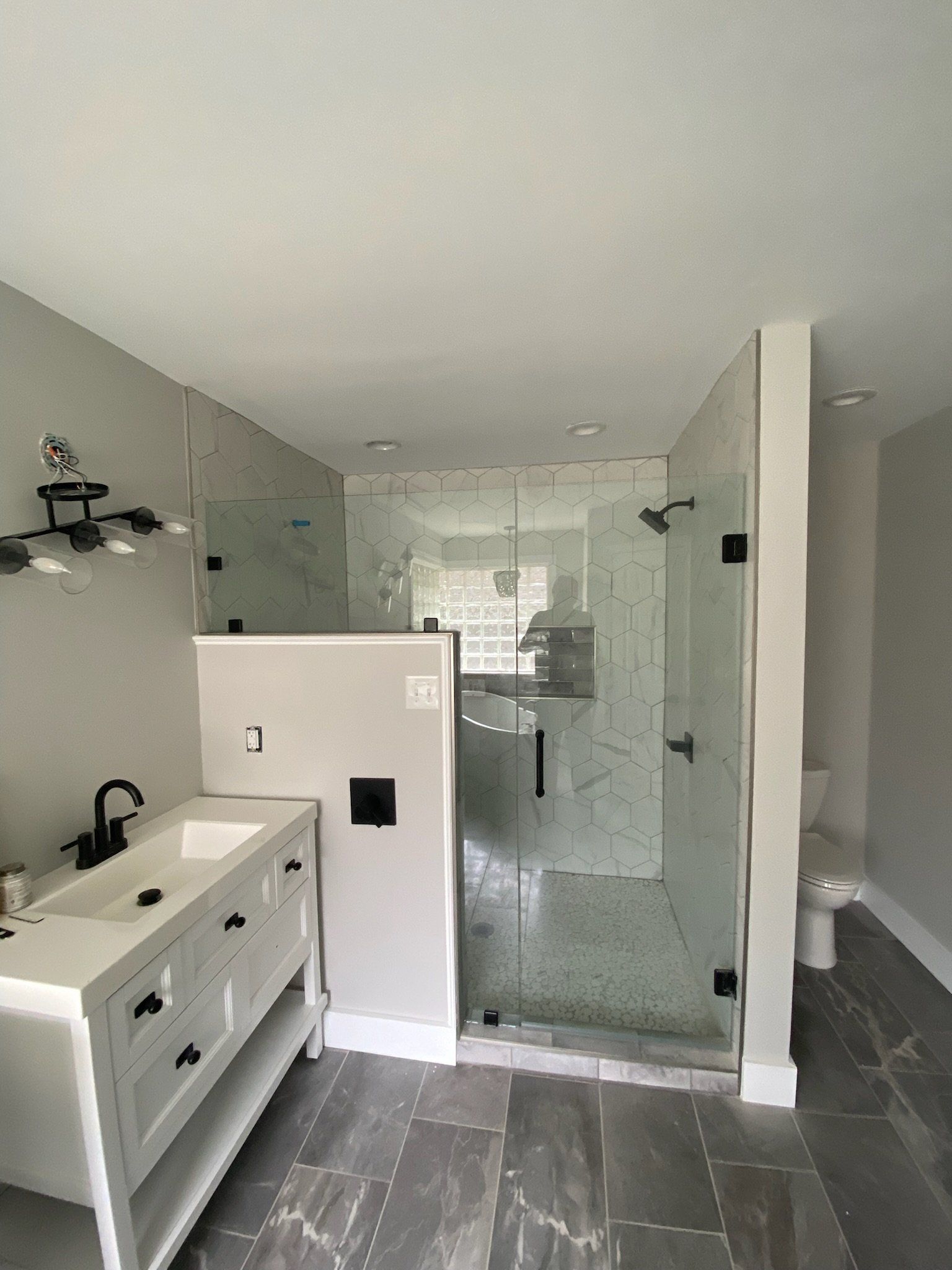 a bathroom with a sink and a frameless shower door