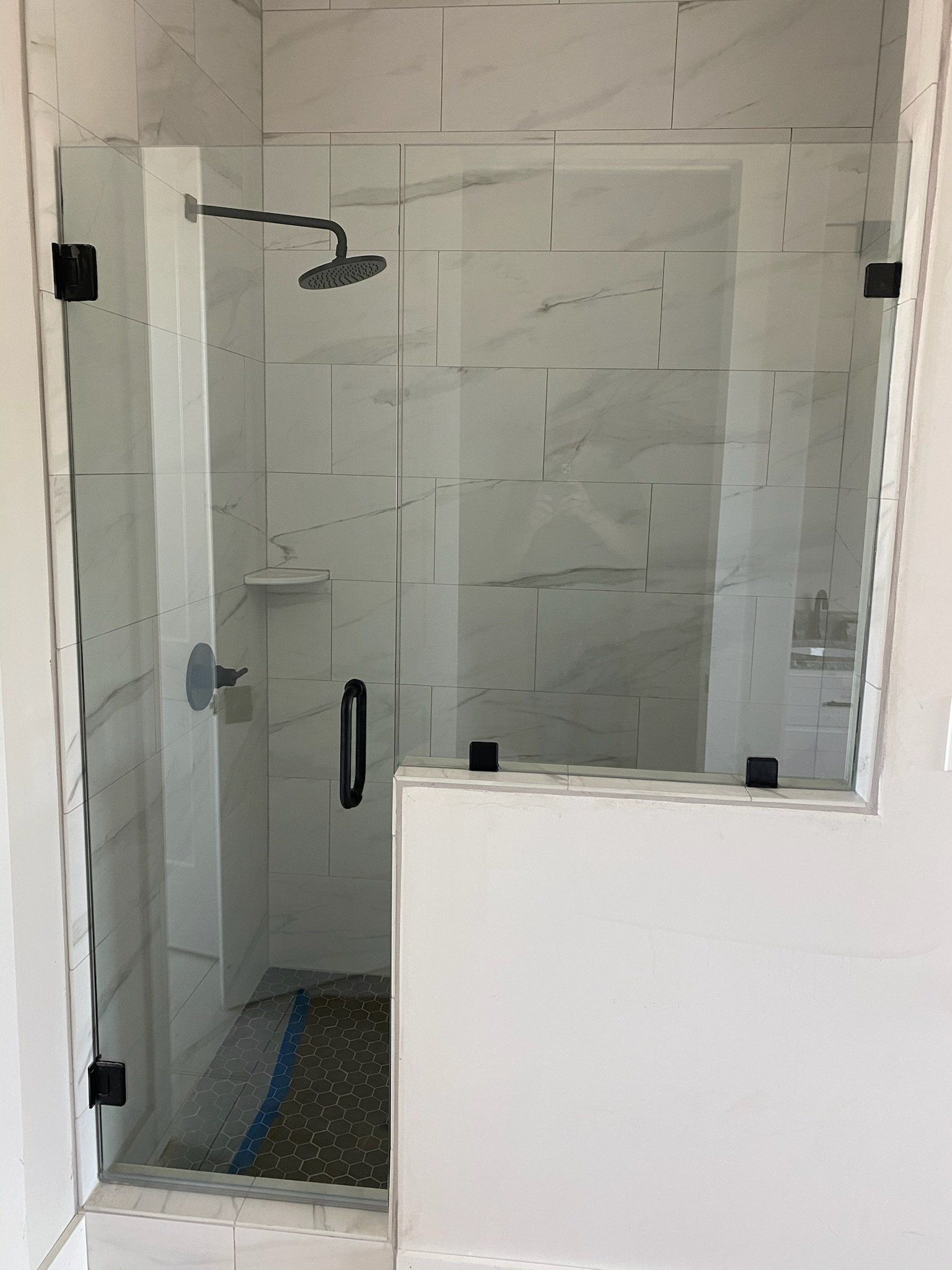 a shower stall with a glass door and a shower head