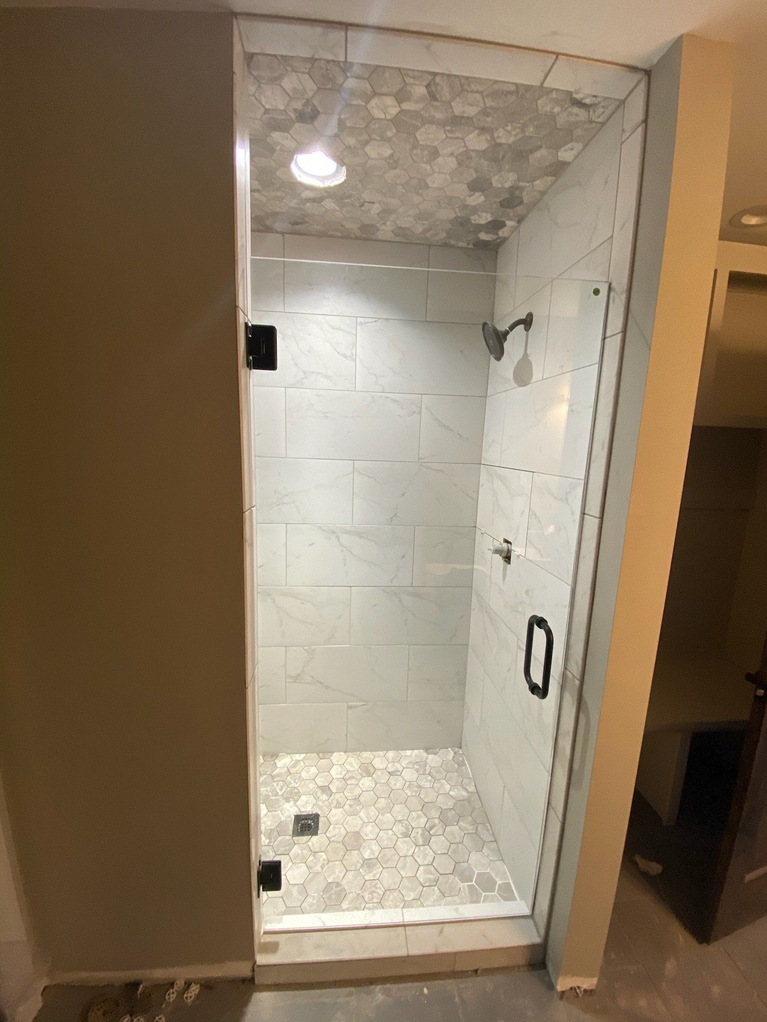 a bathroom with a walk in shower with a frameless glass door