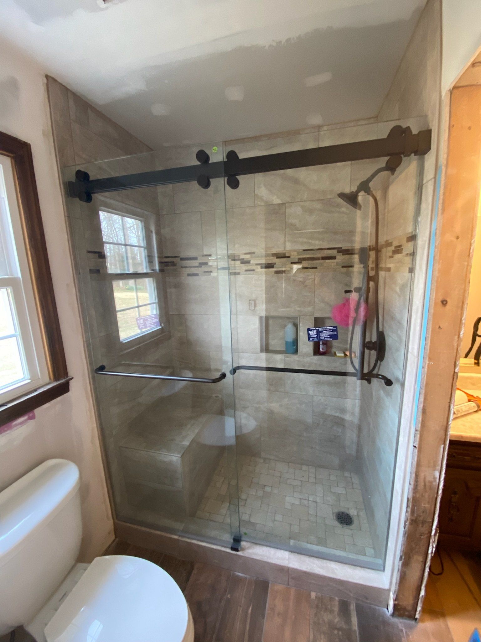 a bathroom with a sliding glass shower door and a toilet