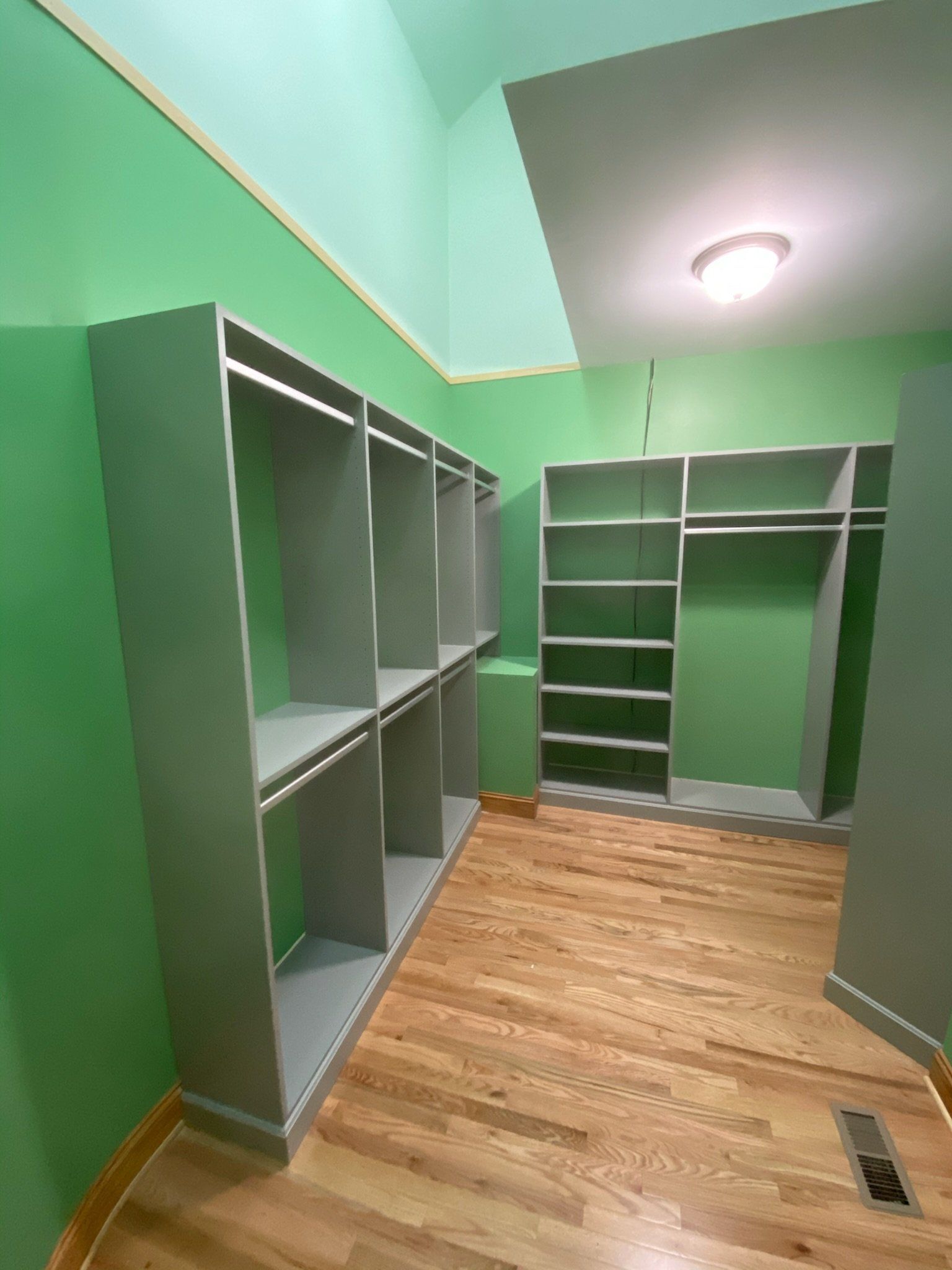 a walk in closet with green walls