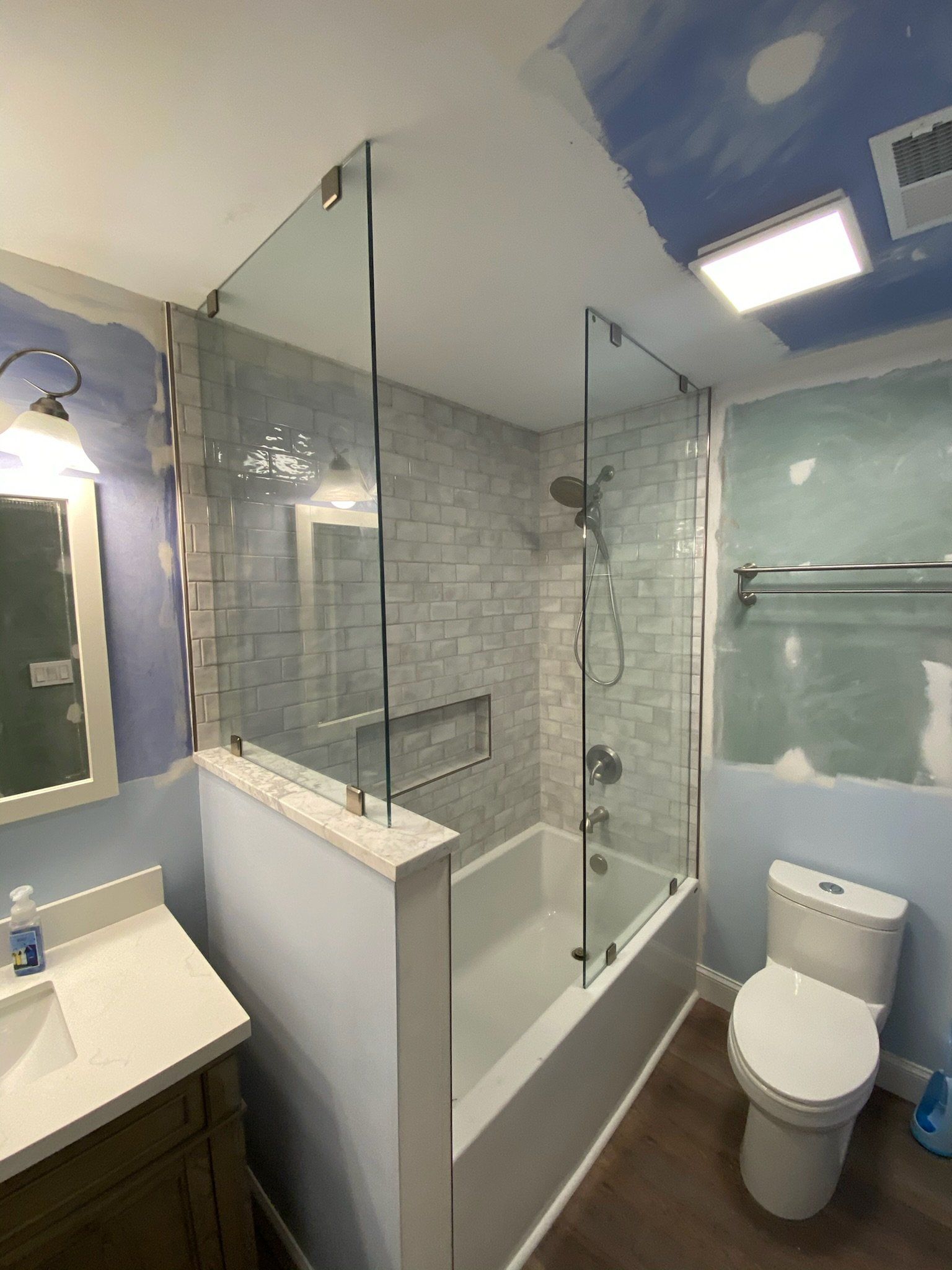 a bathroom with a tub, toilet, sink, and mirror