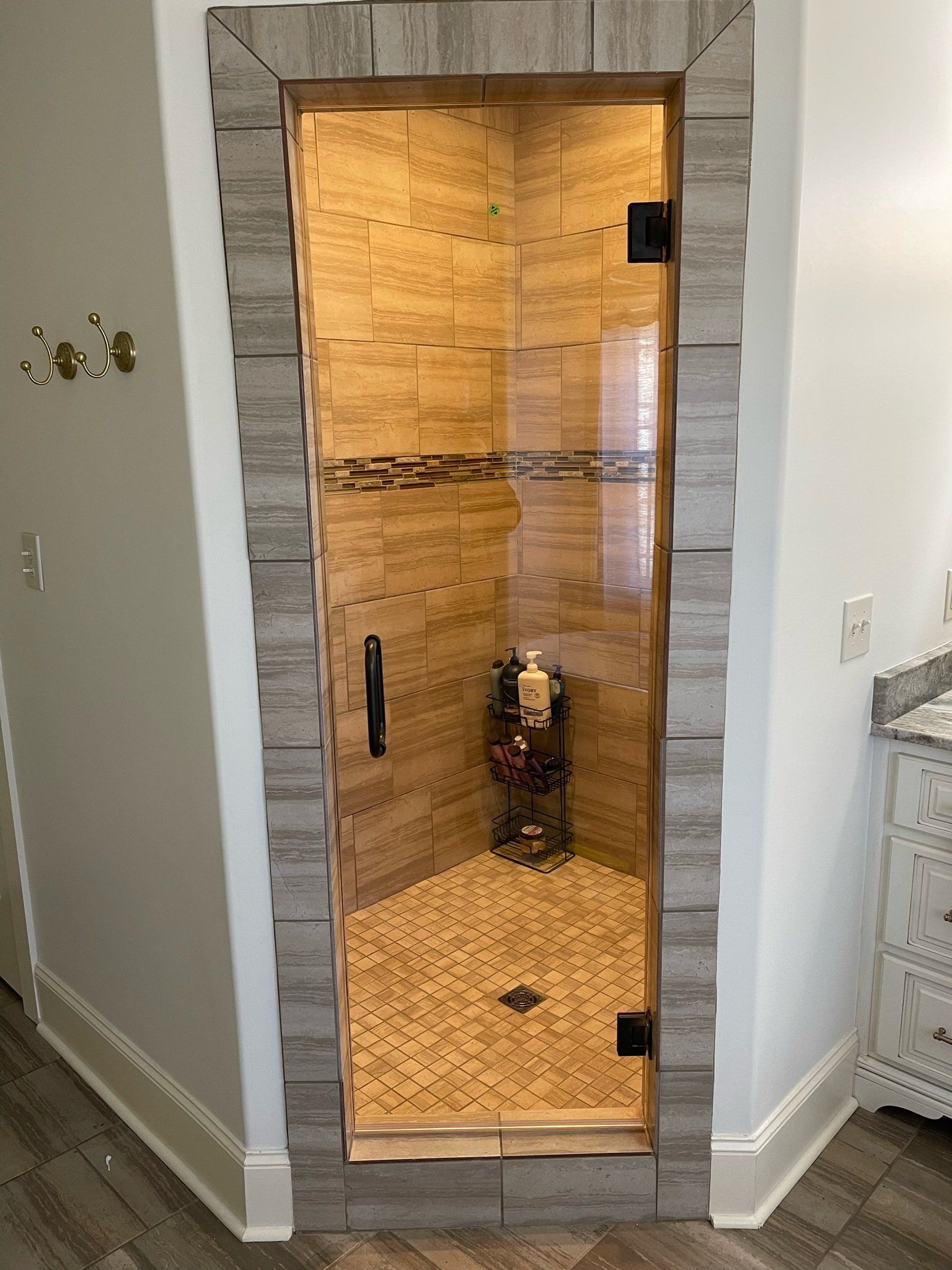a bathroom with a walk in shower with a frameless glass door