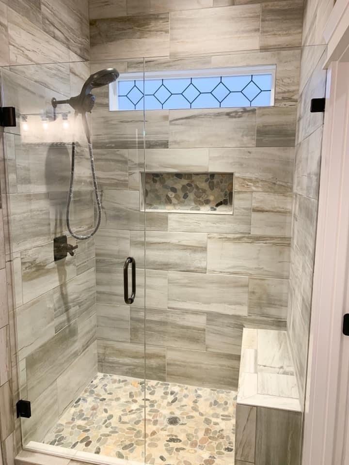 a bathroom with a frameless glass door