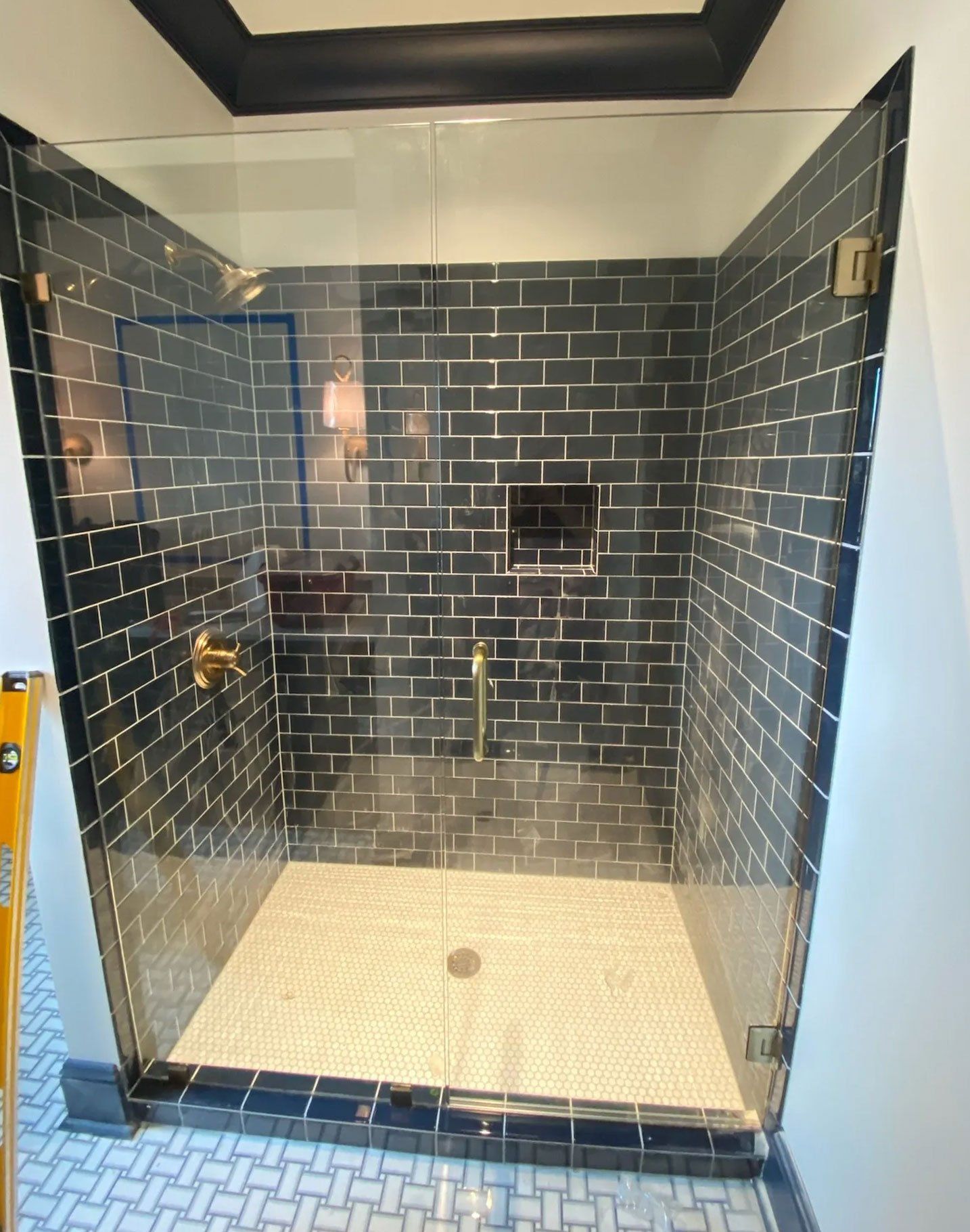 a walk in shower with a frameless glass door