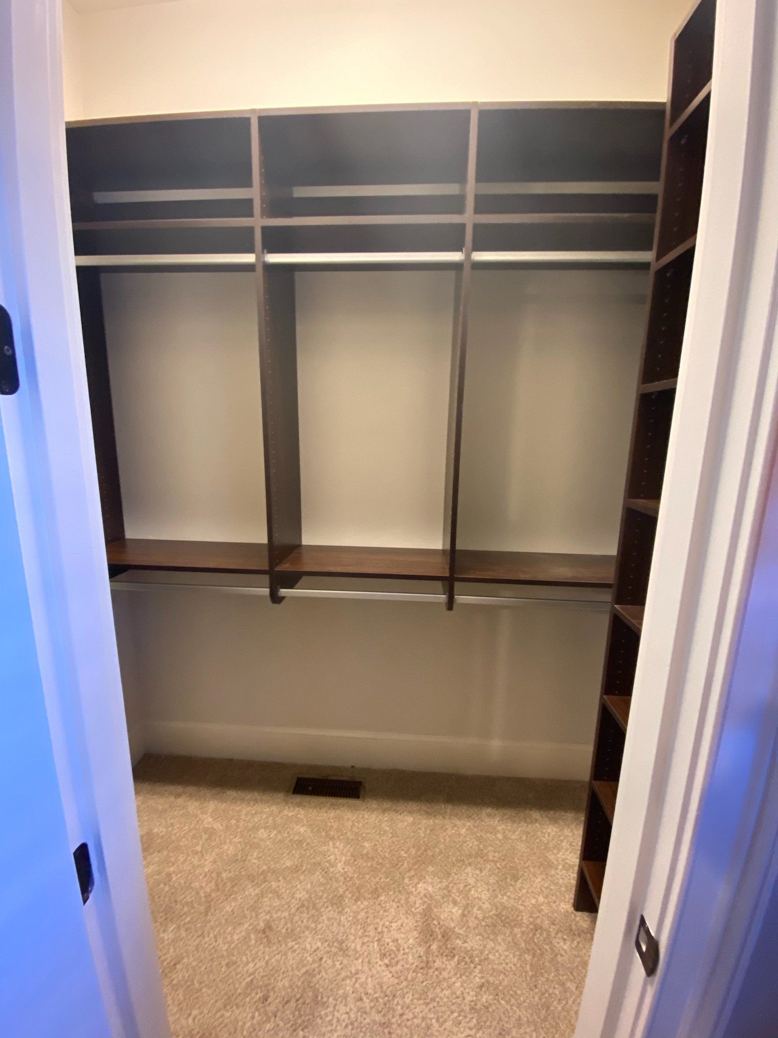 a walk in closet with lots of shelves