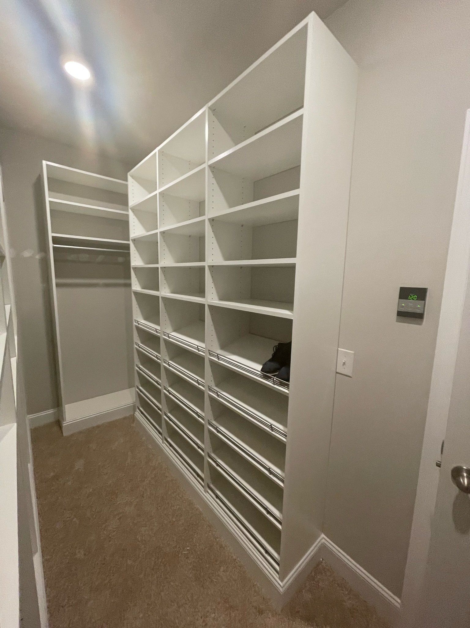 a walk in closet with lots of shelves