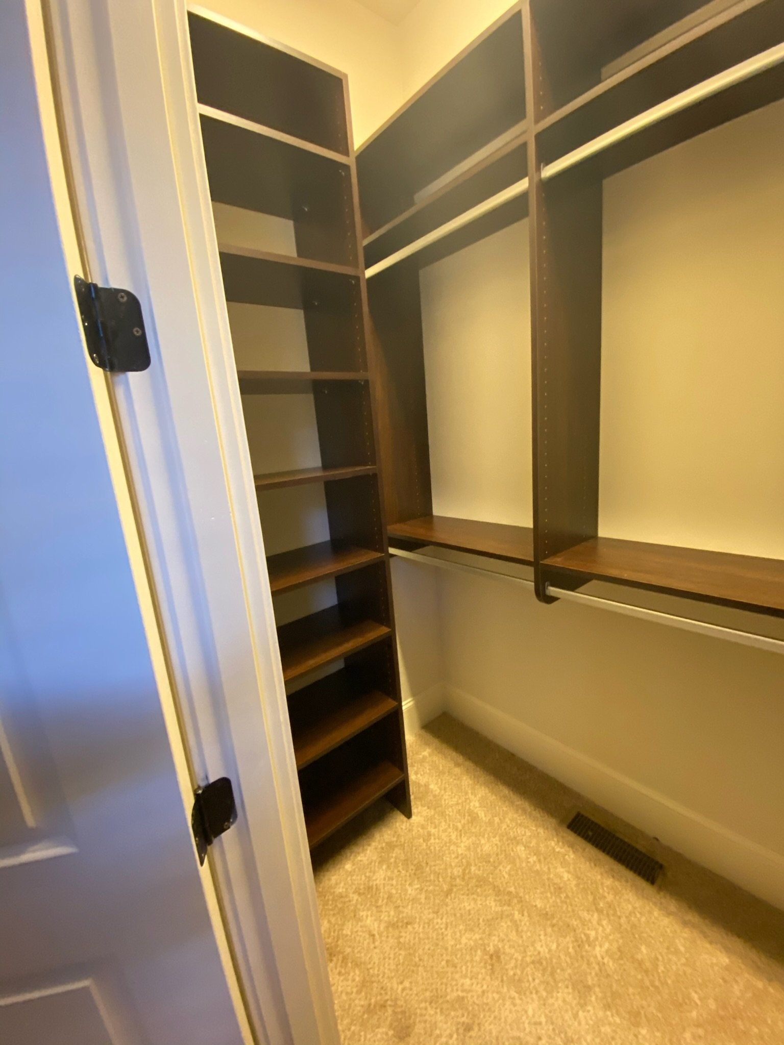 a walk in closet with lots of shelves