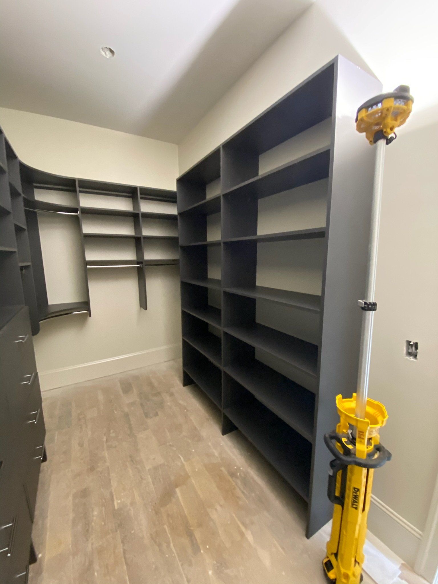 a walk in closet with black drawers and shelves
