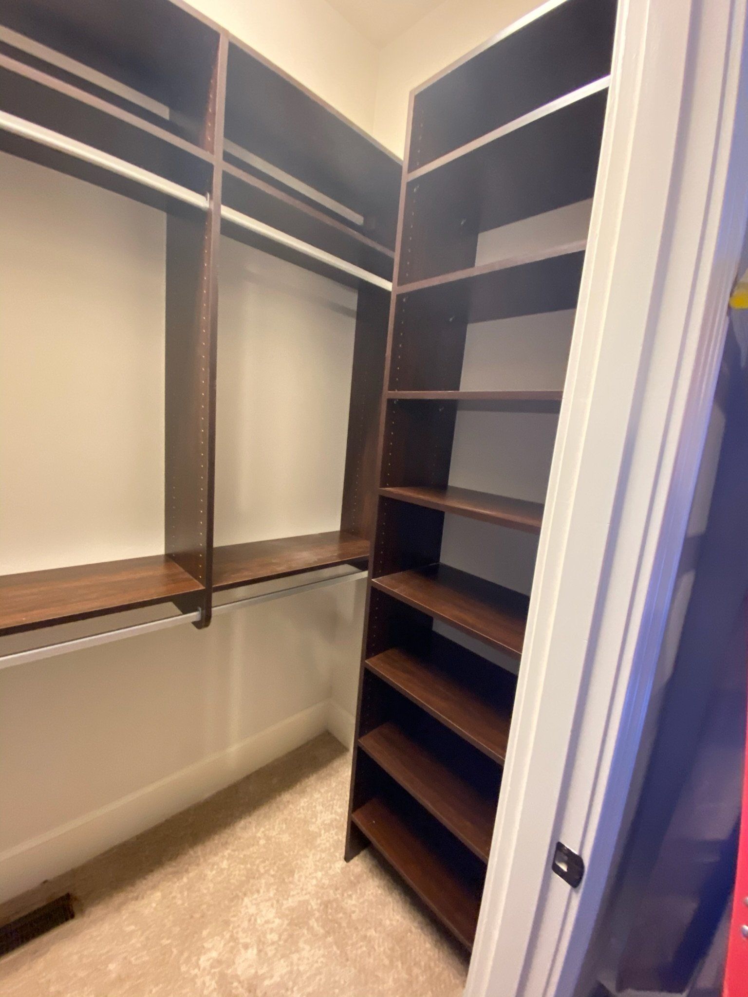 a walk in closet with lots of shelves