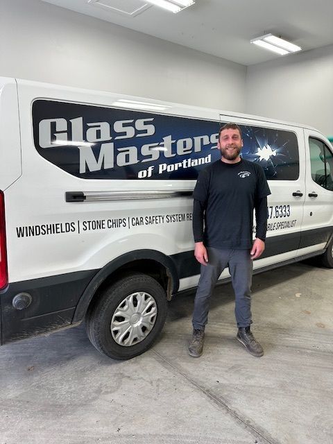 A man is standing in front of a glass masters van.