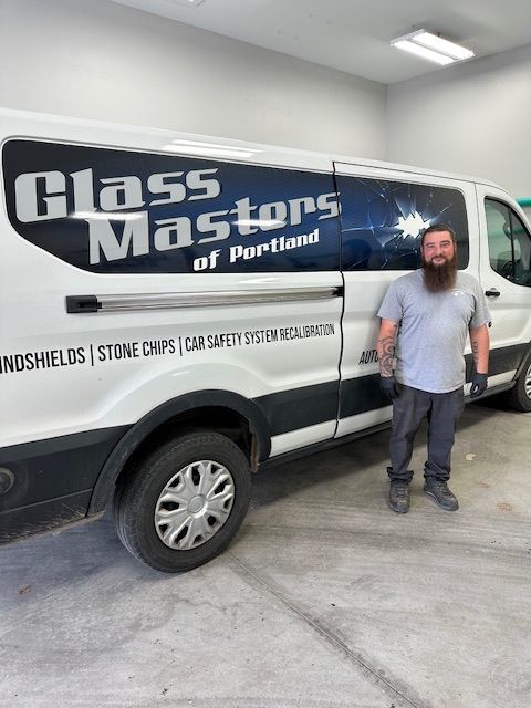 A man is standing in front of a glass masters van.