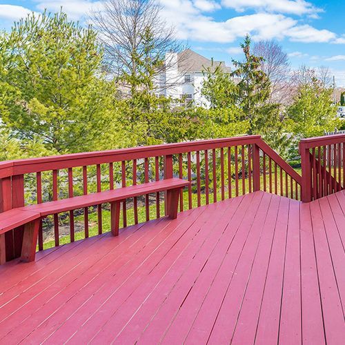 A red deck with a bench and stairs leading up to it