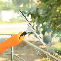 A person is cleaning a window with a squeegee