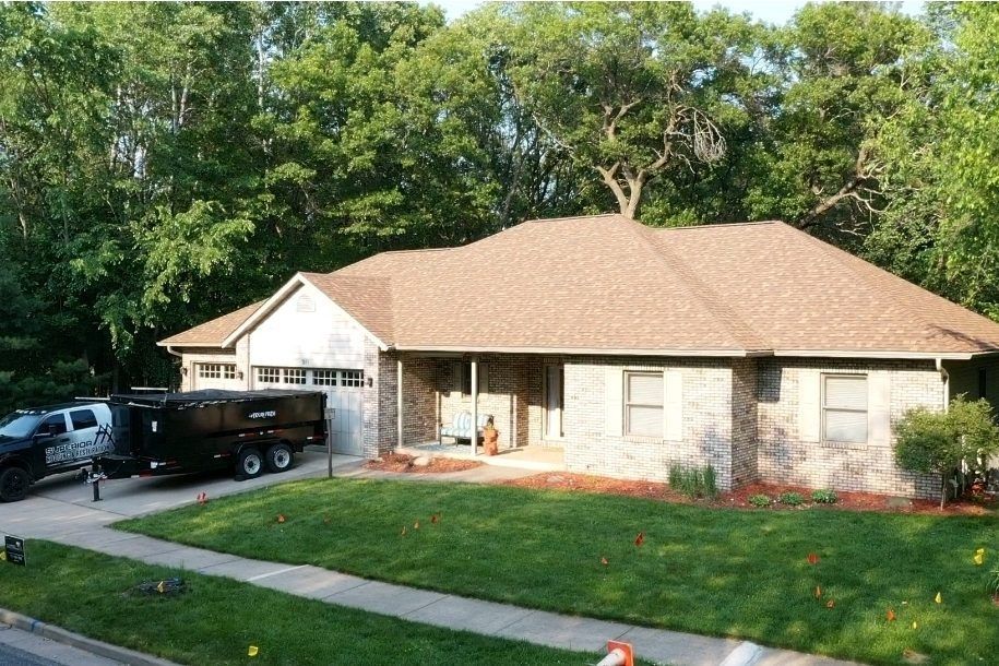 Single-story suburban house with brick facade, attached garage, and a black pickup truck in the driveway