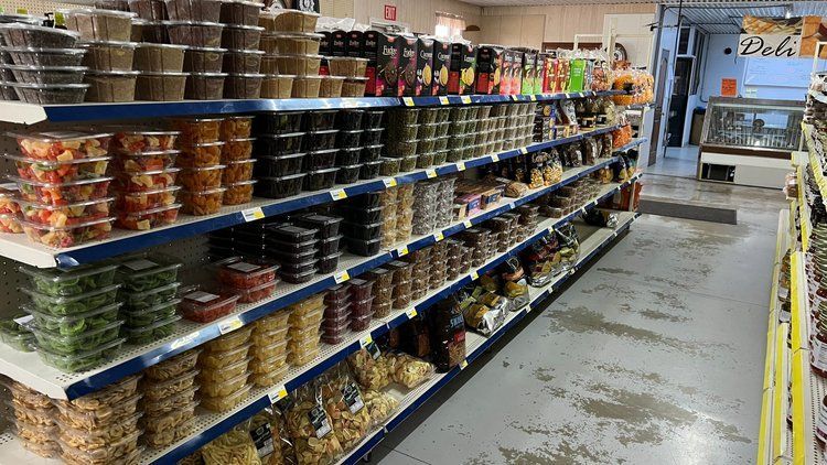 A grocery store aisle filled with shelves filled with lots of food.