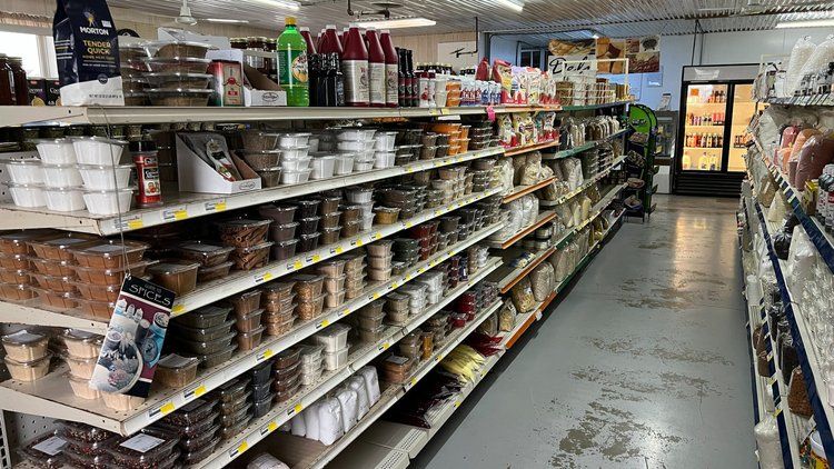 A grocery store aisle filled with shelves filled with lots of food.
