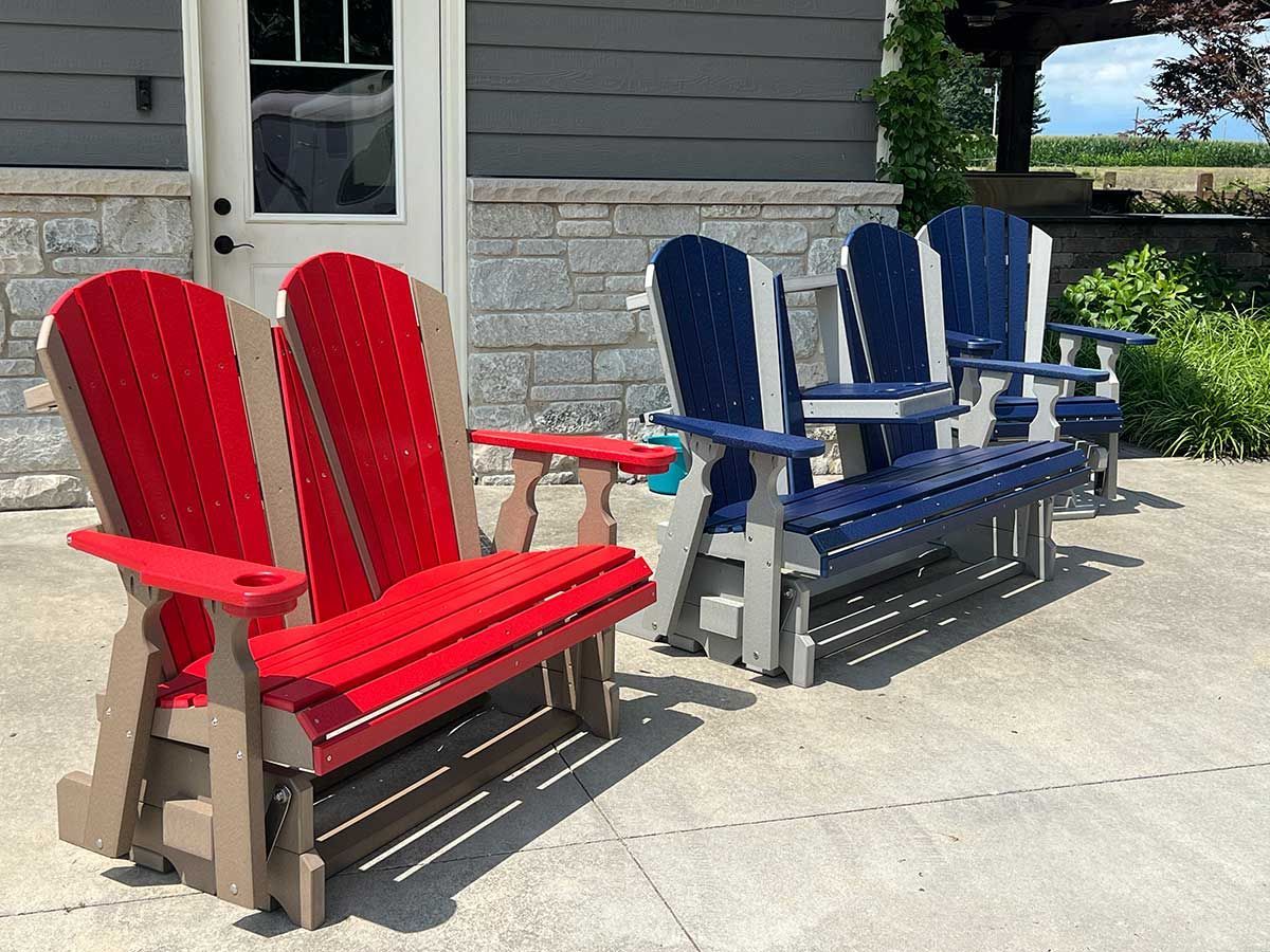 A group of wooden chairs are sitting on a patio in front of a building.