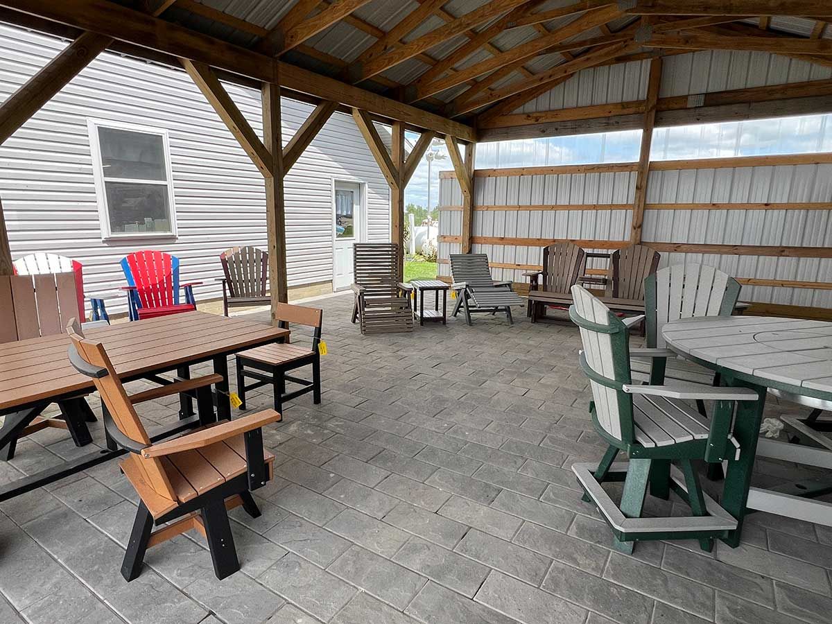 A patio with tables and chairs under a wooden roof.