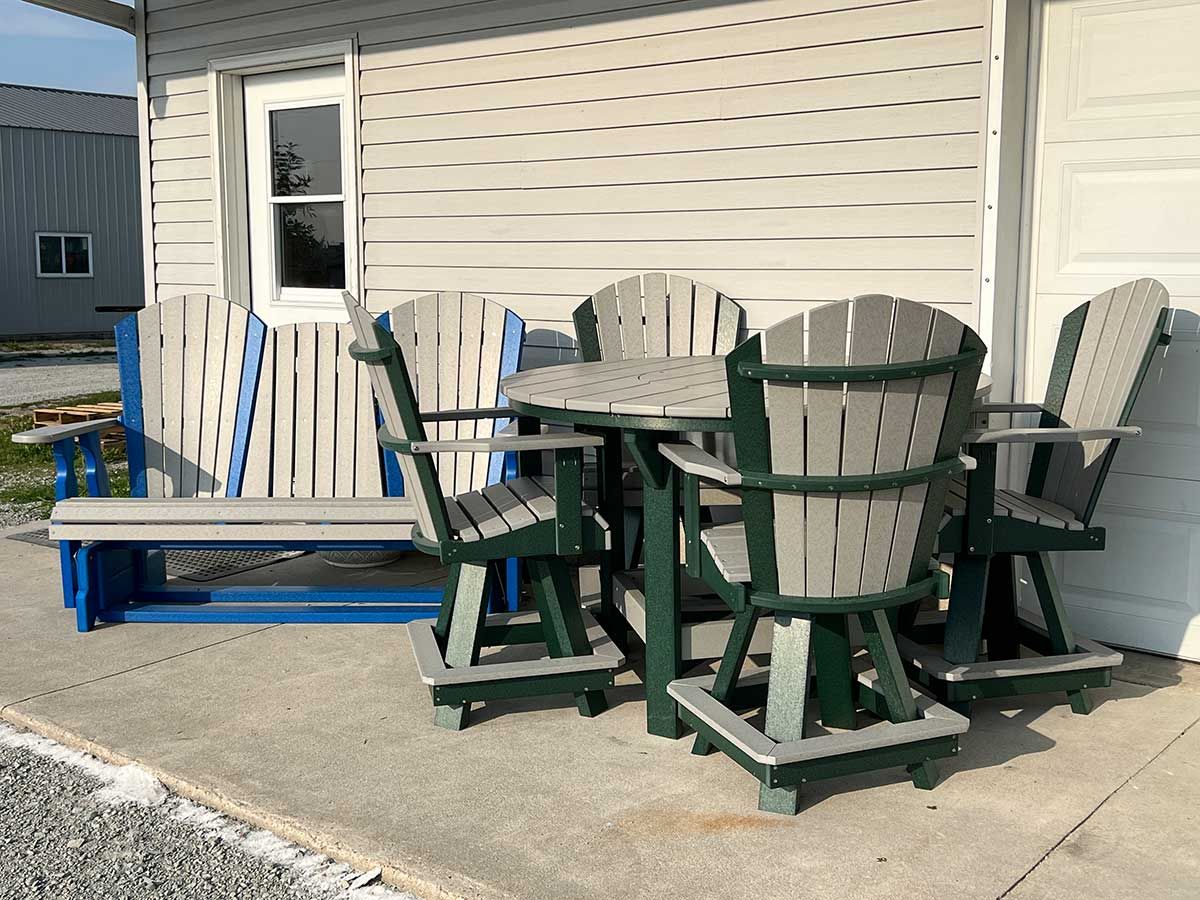 A table and chairs are sitting on a patio in front of a house.