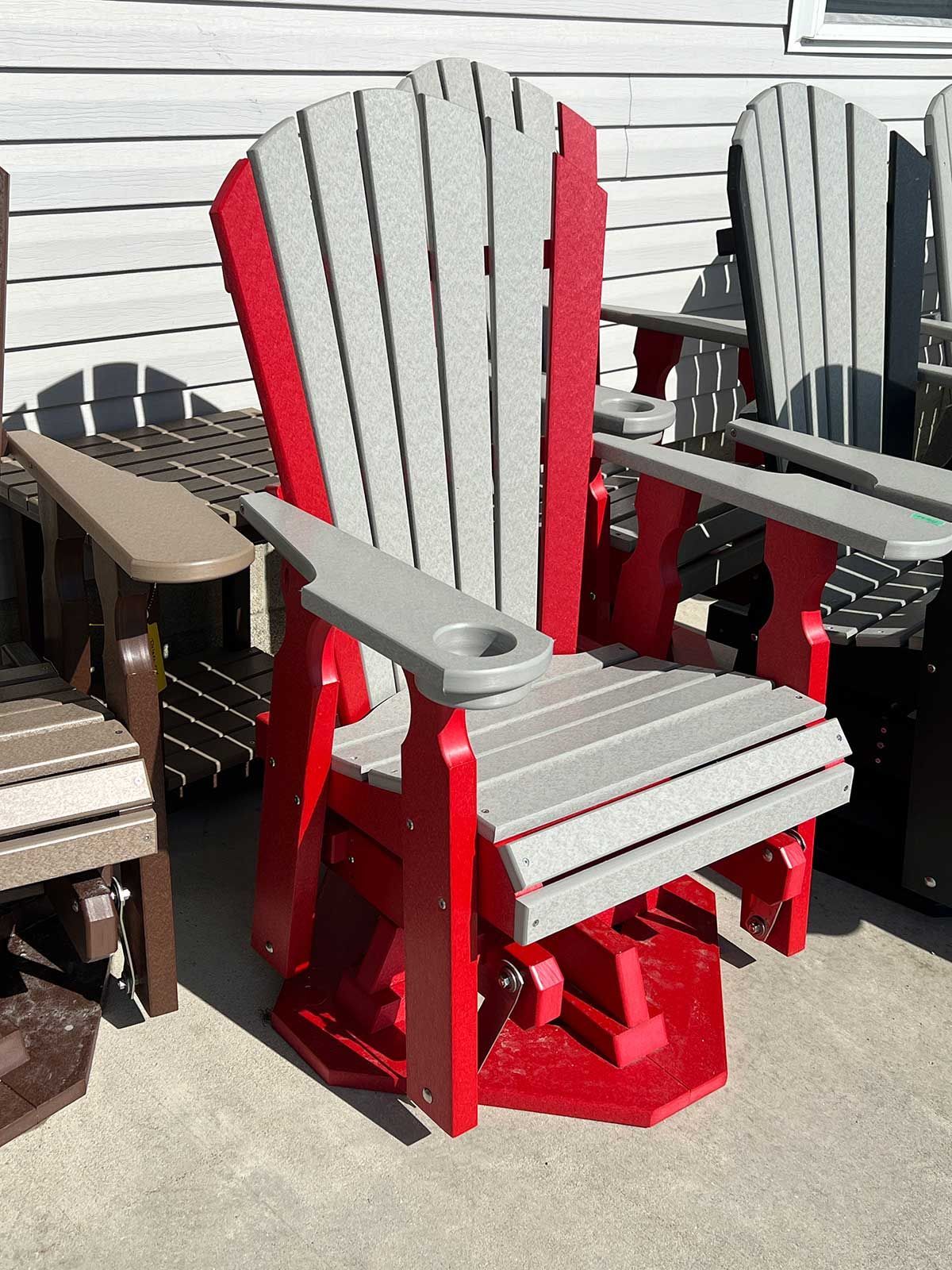 A red and gray chair is sitting on a patio next to other chairs.