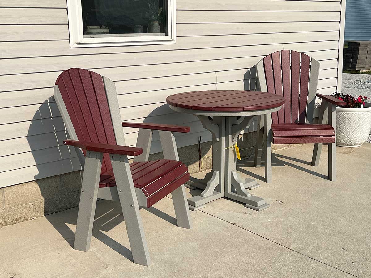 A table and chairs are sitting on a patio in front of a house.