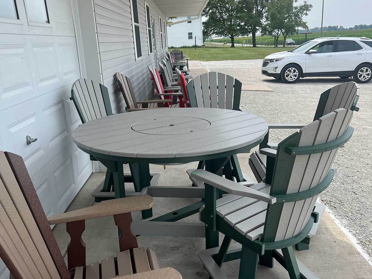 A patio with a table and chairs and a car parked in the background.