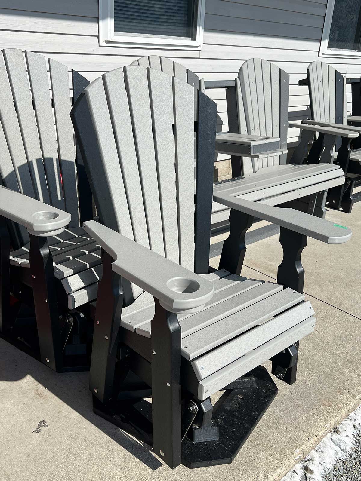 A row of lawn chairs on a sidewalk in front of a house